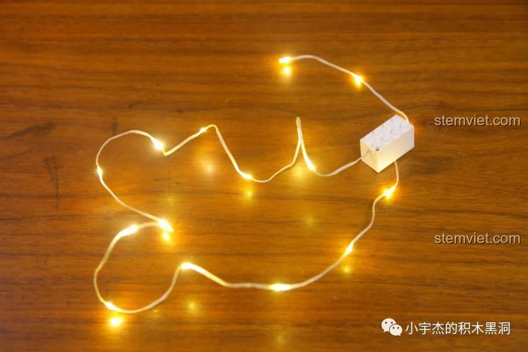 Đèn LED của bộ Hộp Nhạc Giáng Sinh Người Tuyết 601162 phát ra ánh sáng vàng ấm áp.