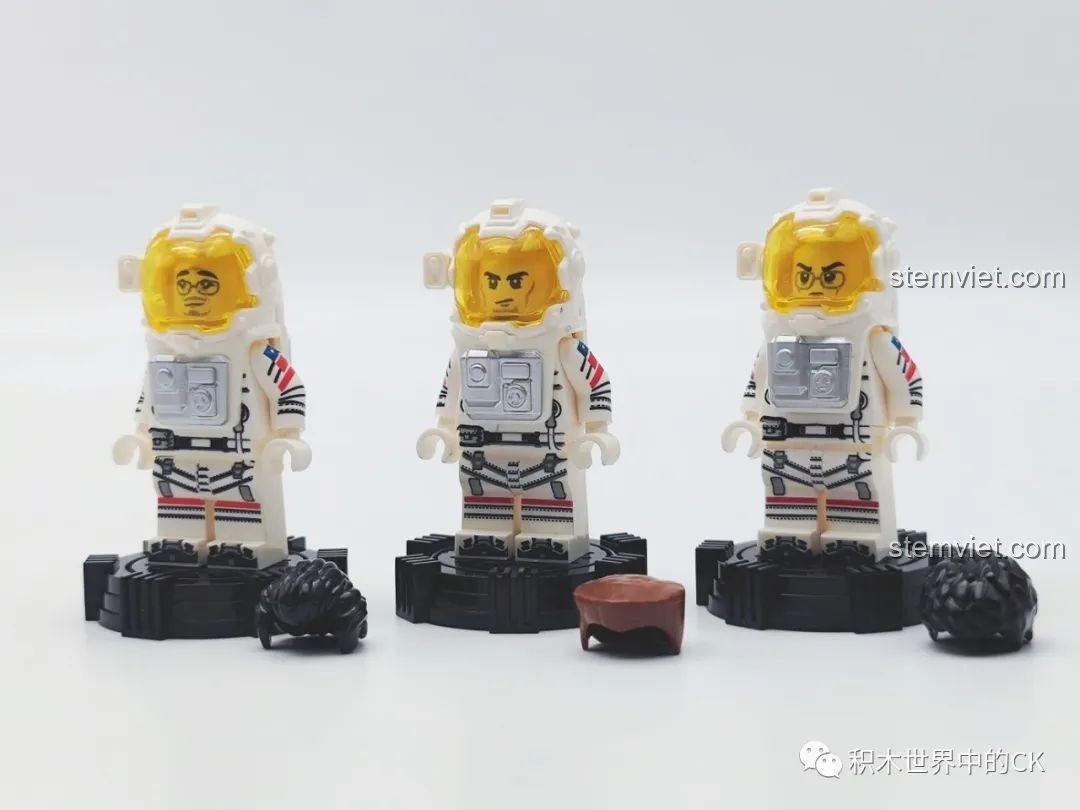 Ba minifigure phi hành gia của bộ lắp ráp Xe thám hiểm vũ trụ 107104 đứng trên đế trưng bày, có thể tháo mũ.
