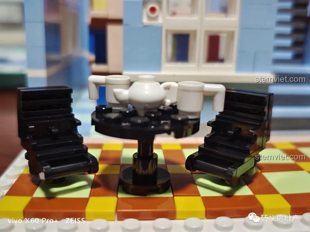 Bộ bàn trà với ấm và tách được đặt ngoài ban công tầng hai, ghế có thiết kế độc đáo.