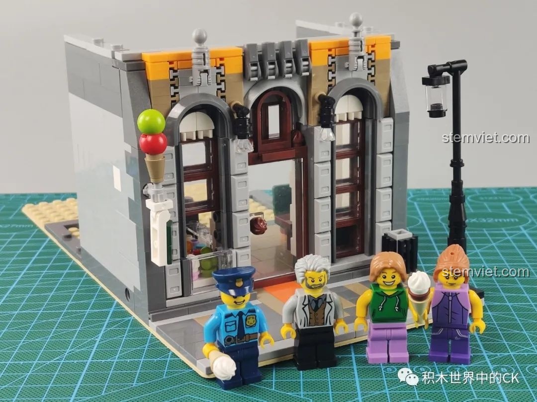 Giai đoạn đầu của quá trình lắp ráp tầng một bộ Leier 10003, với 4 minifigures xếp hàng phía trước cửa hàng.