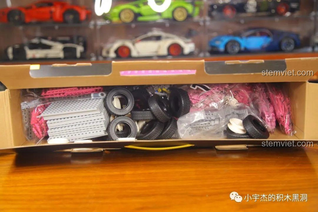 Bên trong hộp đồ chơi lắp ráp Thùng Container Hồng 1:10 YC-QC013, hiển thị các túi mảnh ghép và lốp xe.