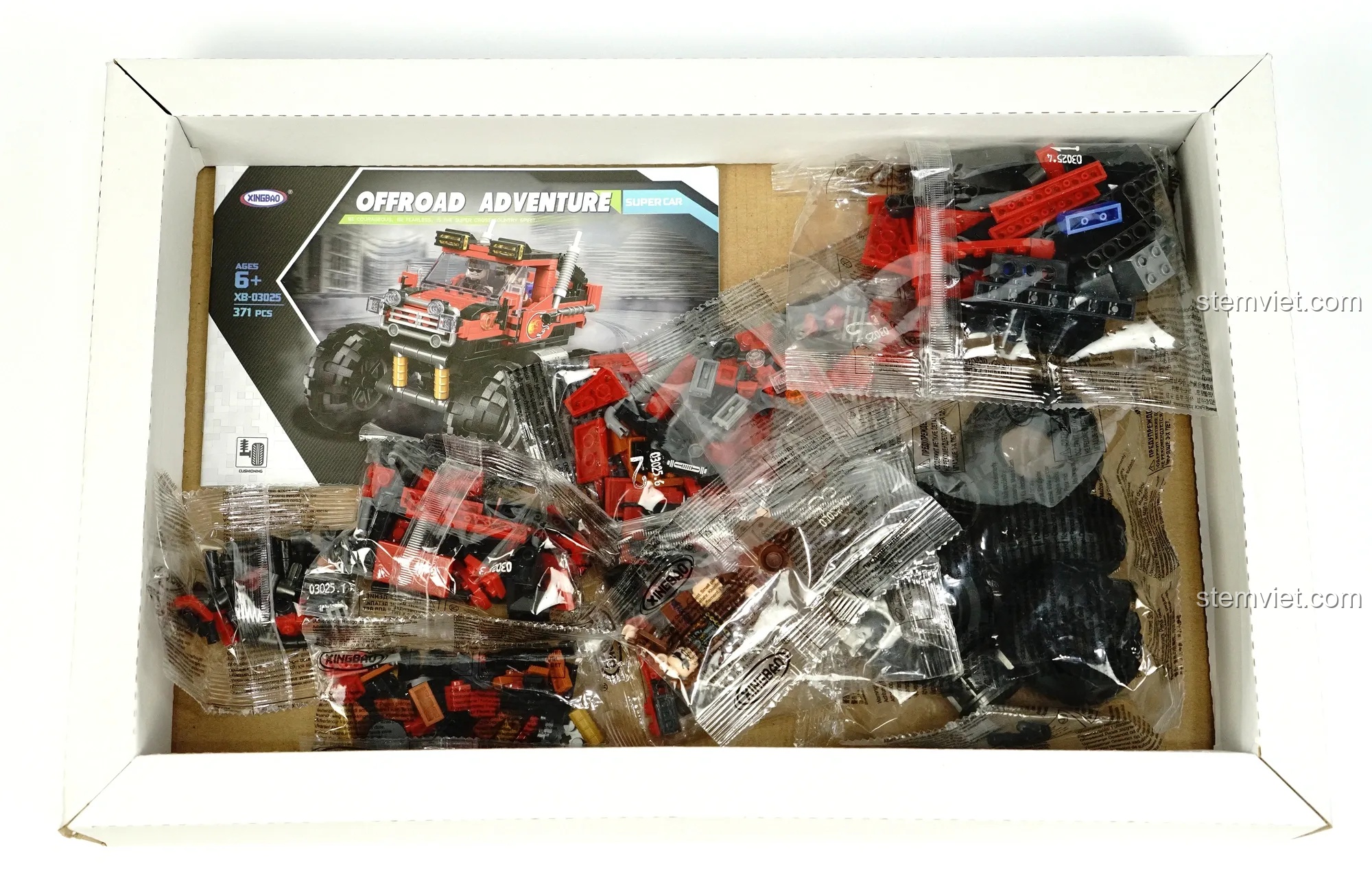 Bên trong hộp đồ chơi xây dựng Xe địa hình bánh lớn 3025 có khay đựng và các túi chi tiết được phân loại.