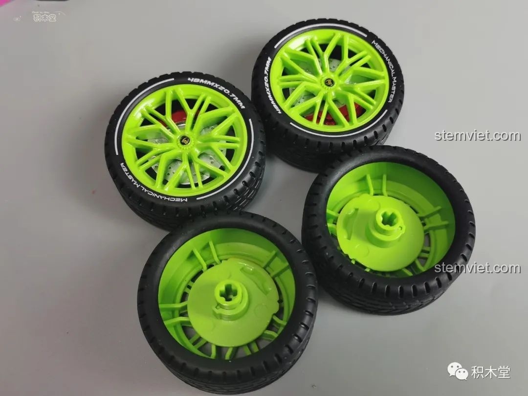 Bộ bốn bánh xe của mô hình Wanzhi 9803 với lốp cao su có chữ và mâm xe màu xanh neon nổi bật.