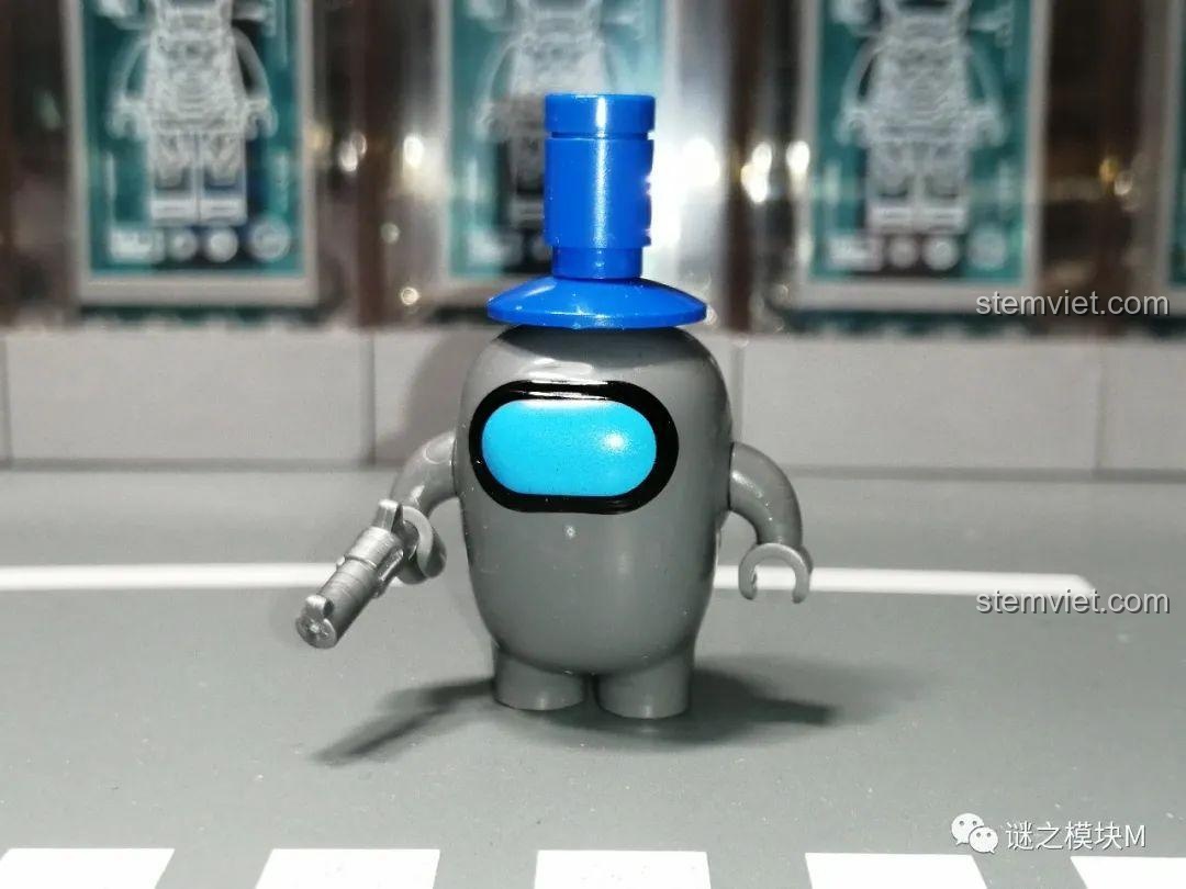 Phi hành gia Xám trong bộ lắp ghép Among Us PRCK 69702, chi tiết mũ và súng được tái hiện chân thực, tăng tính thẩm mỹ.