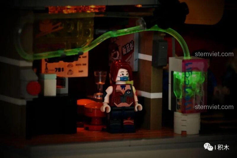 Minifigure bên cạnh ống đèn xanh độc đáo của bộ đồ chơi BrickCool KS002 Cửa hàng Sushi Cyberpunk, đồ chơi lắp ghép giá tốt, đáng tiền.