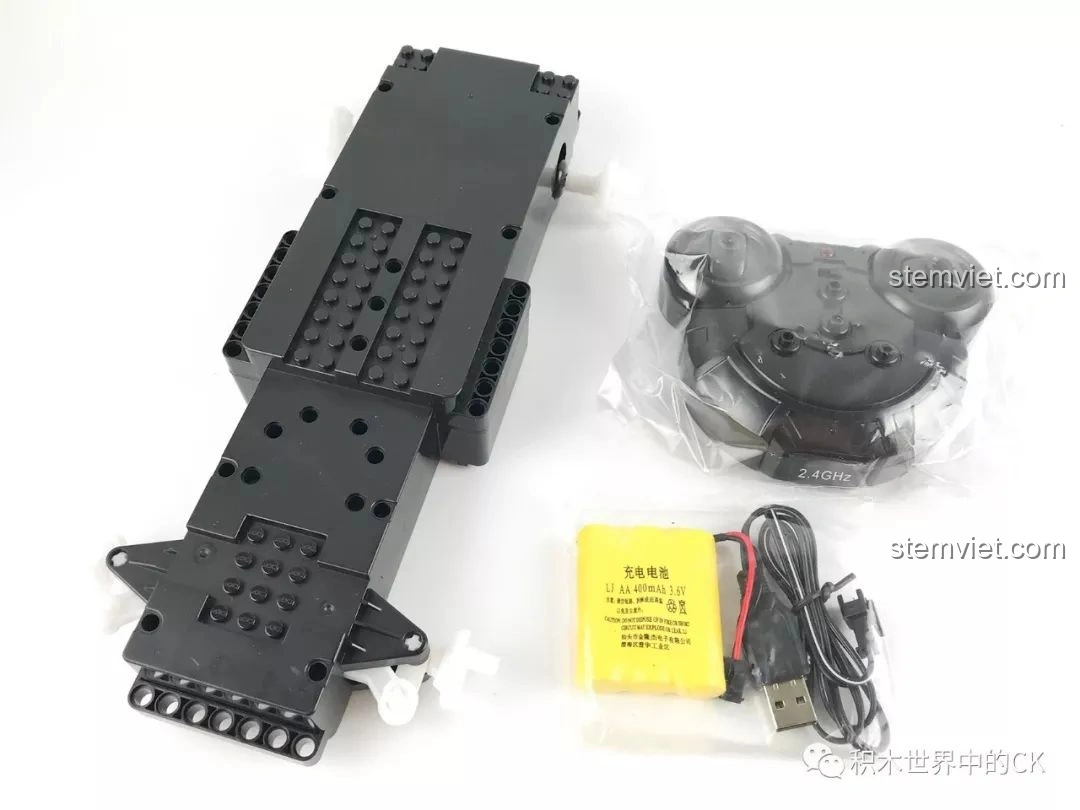 Khung gầm liền khối màu đen và tay cầm điều khiển hình chuột của xe bán tải CaDA C51005 RC.