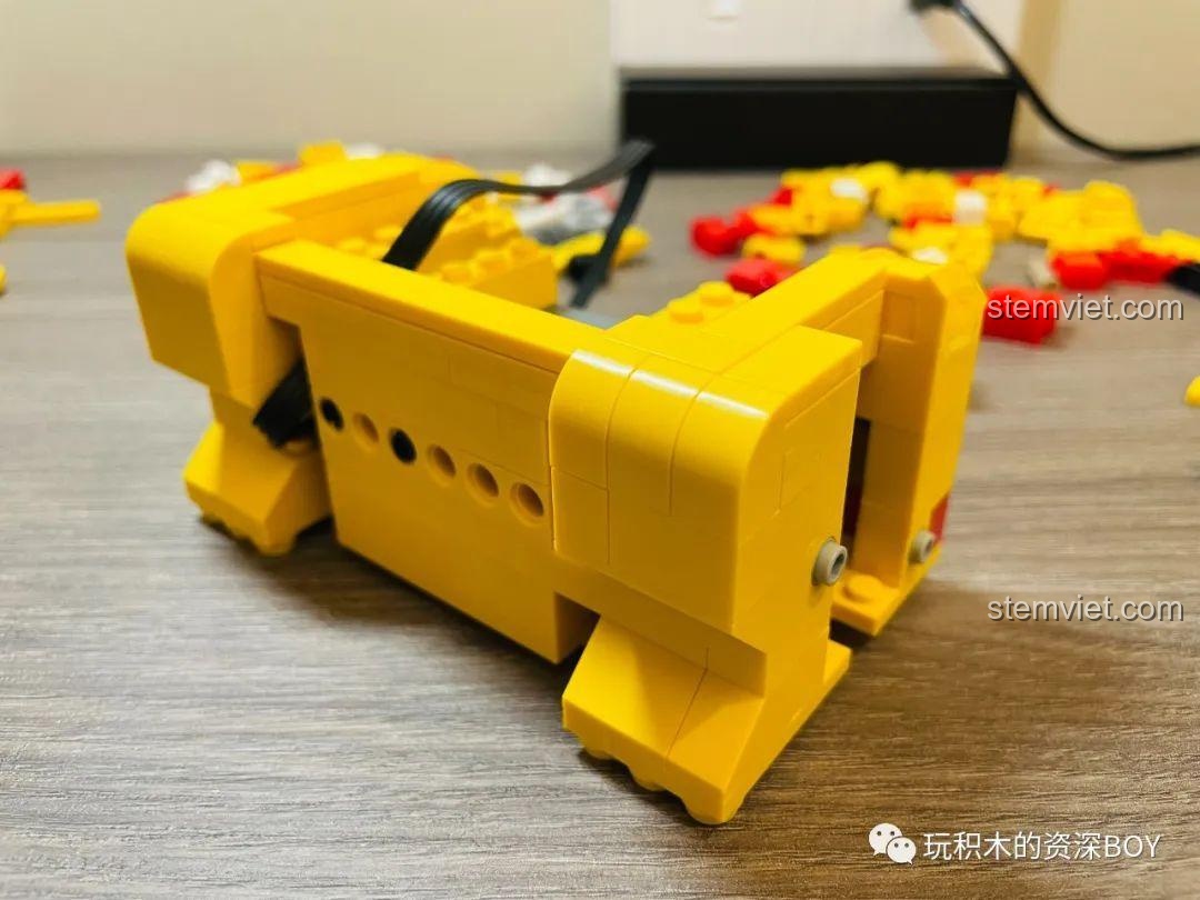 Phần đế của bộ đồ chơi CaDA C51037 Mèo Thần Tài đang được hoàn thiện, cho thấy sự kết nối giữa các mảnh ghép và động cơ, ảnh review người dùng chụp.