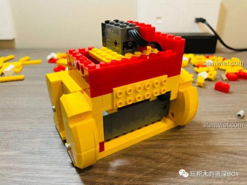 Phần thân của bộ lắp ghép CaDA C51037 Mèo Thần Tài đang dần hình thành, với các khối màu vàng tạo nên hình dáng cơ bản, ảnh review người dùng chụp.