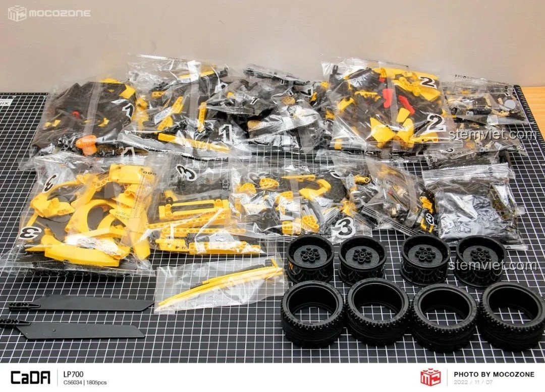 Các mảnh ghép của bộ CaDA C63004 Lamborghini Aventador LP700 được phân loại và sắp xếp trên bàn, sẵn sàng cho việc lắp ráp.