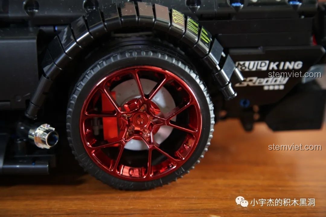 Cận cảnh bánh trước của mô hình Xe đua Ford Mustang Hoonicorn V2 với mâm đỏ và vè xe chi tiết.