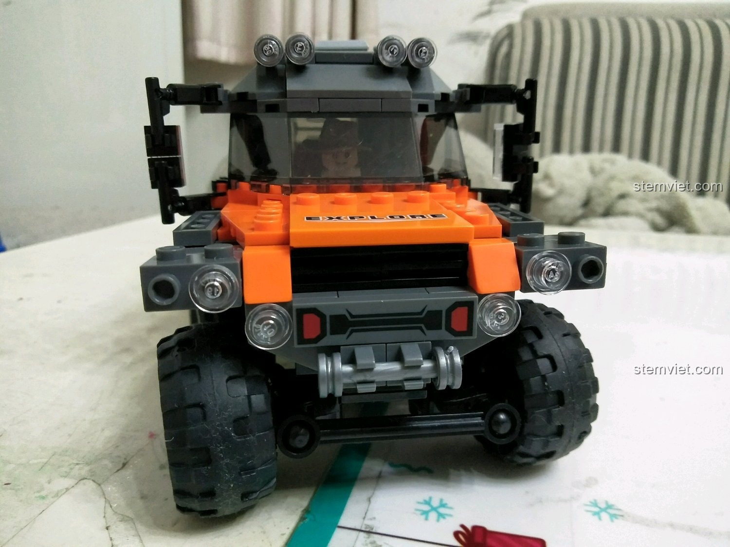 Cận cảnh phần đầu của mô hình xe off-road 8 bánh XB03027 với các chi tiết đèn, cản trước và chữ EXPLORE.