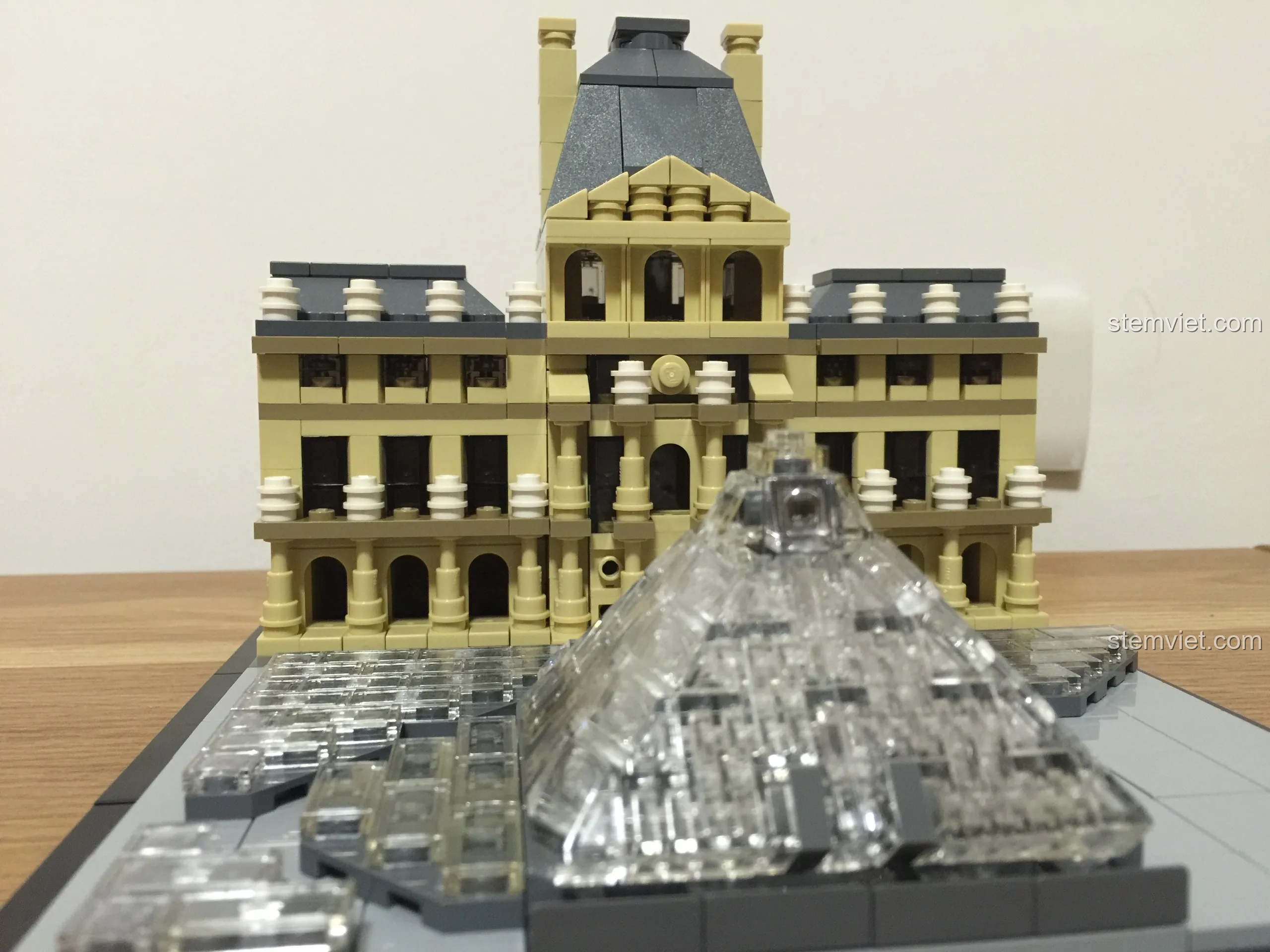 Góc nhìn cận cảnh mô hình LEGO 21024 Louvre hoàn chỉnh, tập trung vào sự tương phản giữa cung điện và kim tự tháp.