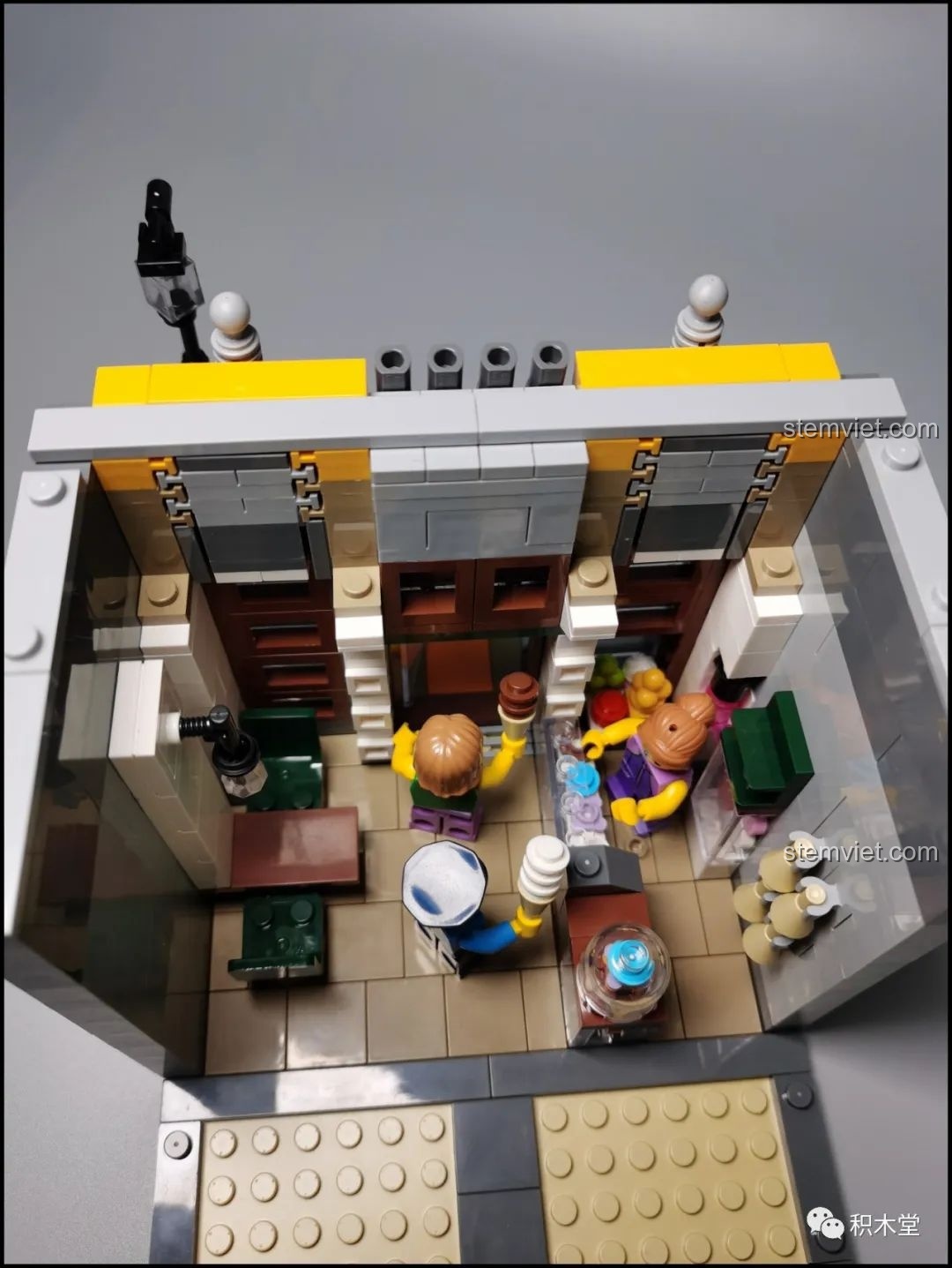 Minifigure cảnh sát đang mua kem tại cửa hàng ở tầng 1 của bộ Leier 10003, một cảnh tượng vui nhộn.