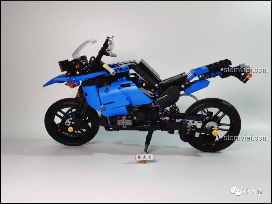 Mô hình Leier 50008 Mô tô BMW R1200GS Rallye nhìn từ bên hông với chân chống đang được dựng, sẵn sàng trưng bày.