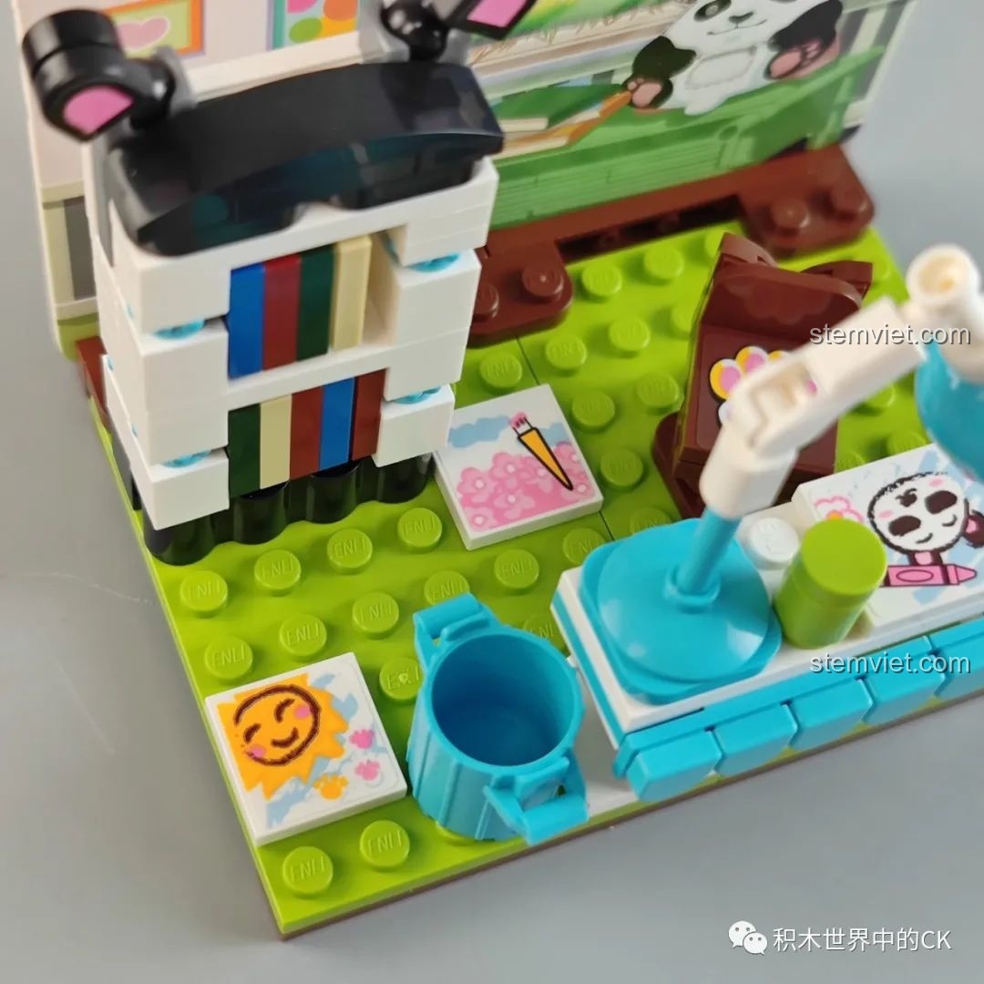 Chi tiết bàn học với đèn, sách và bút màu trong set đồ chơi Panda.