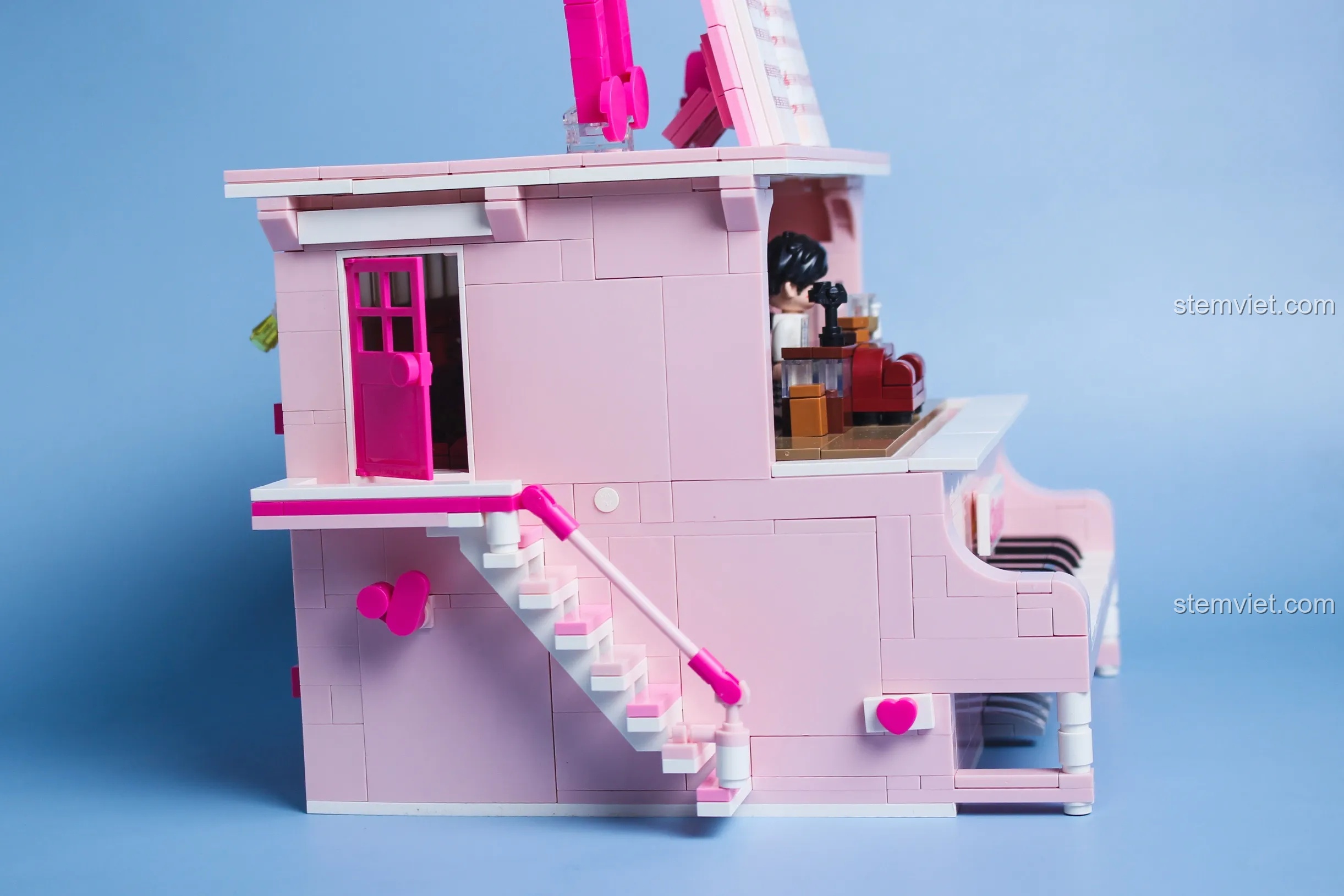 Mặt bên của đàn piano Keeppley DZ0155 với chi tiết cầu thang và cánh cửa màu hồng đậm.