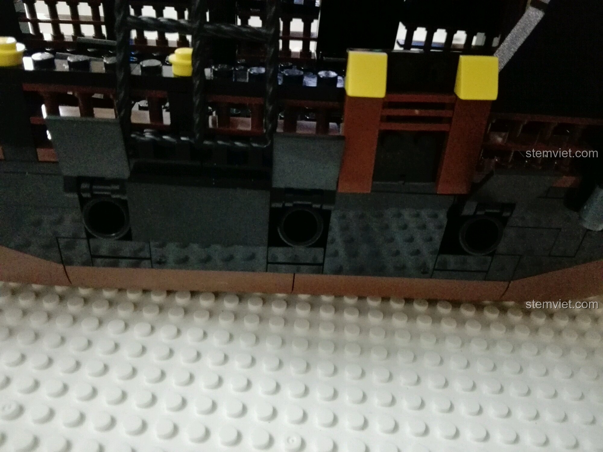 Cận cảnh chi tiết cửa sổ ở đuôi tàu GUDI 9115, với hoa văn lưới màu vàng.