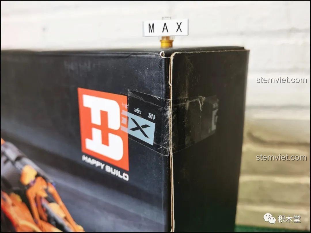 Miếng dán niêm phong hộp Happy Build YC-QC004 với logo hãng, thể hiện sự chú trọng chi tiết và chất lượng sản phẩm trong review.