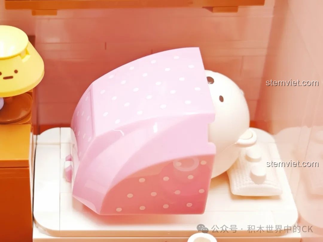 Cận cảnh nhân vật Shirokuma đang ngủ trong chăn hồng chấm bi, một chi tiết đáng yêu của bộ đồ chơi Keeppley Sumikko Gurashi.