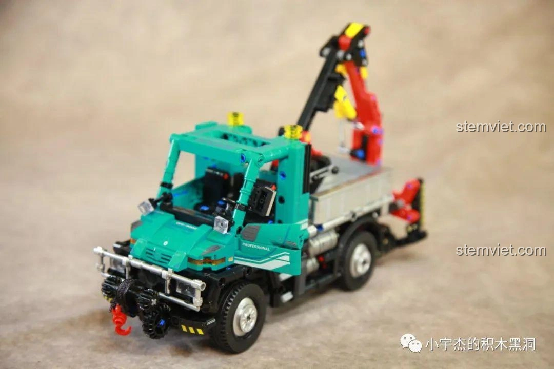 Thùng xe của Xe tải công trình Unimog U400 SEMBO Block 720900 đang lật nghiêng để đổ các khúc gỗ.