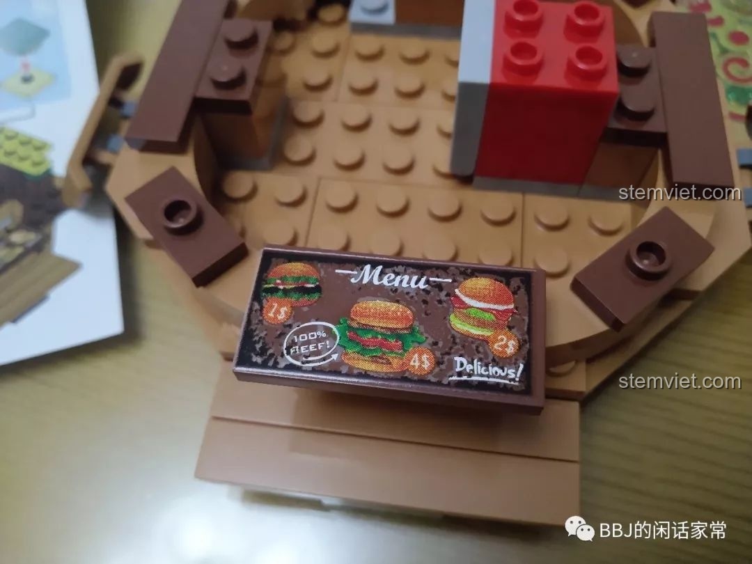 Quá trình dán sticker menu lên một mảnh ghép của bộ xếp hình Mô Cửa Hàng Hamburger 1055.