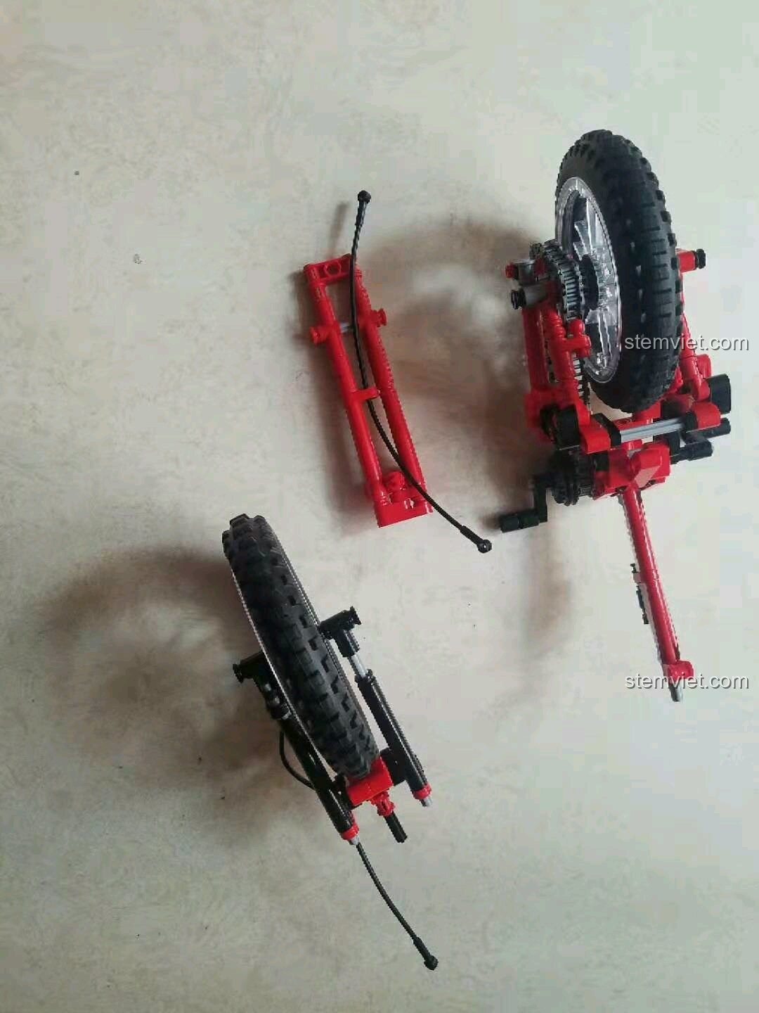 Sợi xích dài của xe đạp Sembo 703302 được đặt cạnh phần khung sau đã lắp bánh xe.