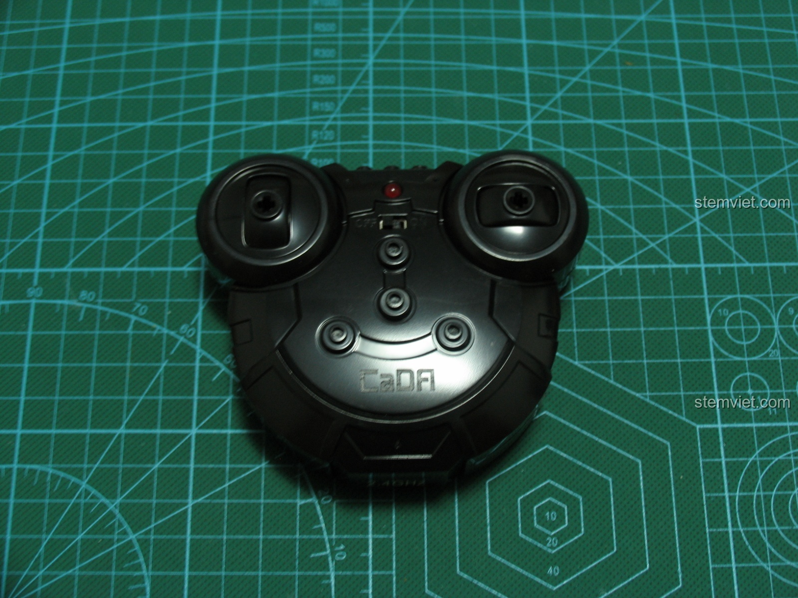 Bộ điều khiển từ xa của CaDA C51005 Xe Bán Tải Đỏ nhìn từ mặt trước, với các nút điều hướng và đèn báo trạng thái.