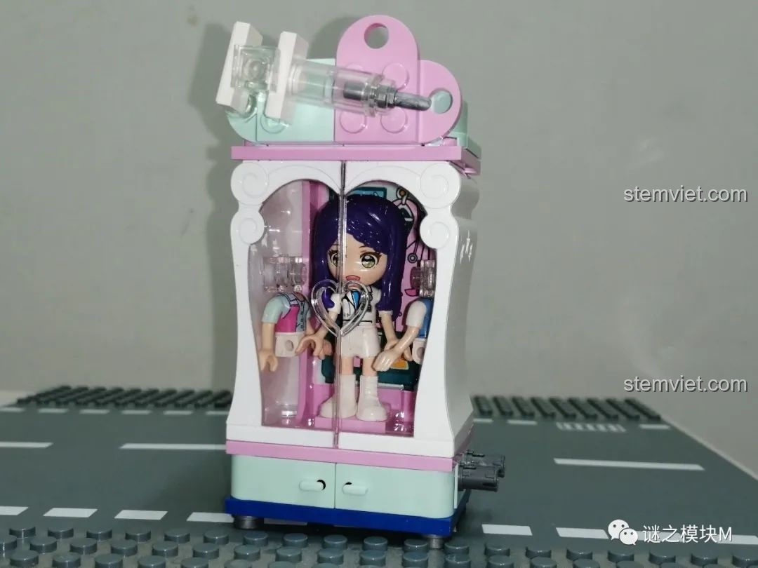 Tủ đồ của Bác sĩ UNA trong bộ đồ chơi QMAN 34011, màu sắc nhẹ nhàng và có ống tiêm trang trí.