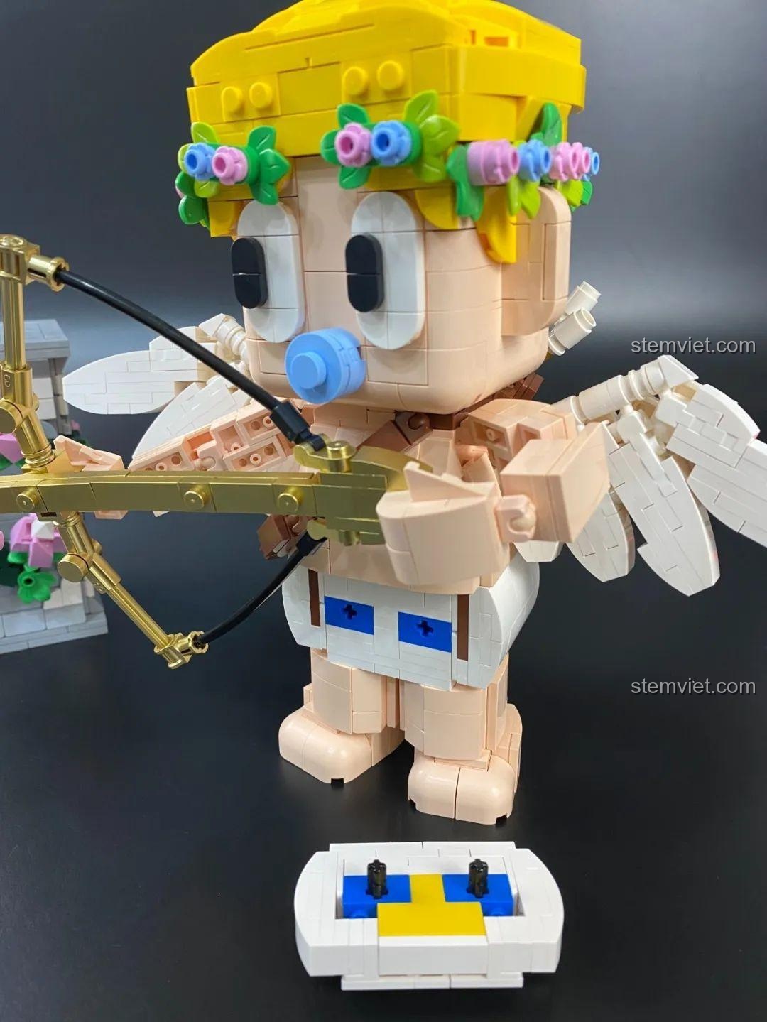 Góc nhìn nghiêng của bộ đồ chơi lắp ghép Mô hình Cupid 846 681 ngồi trên bệ, tập trung vào chi tiết chân và tay.