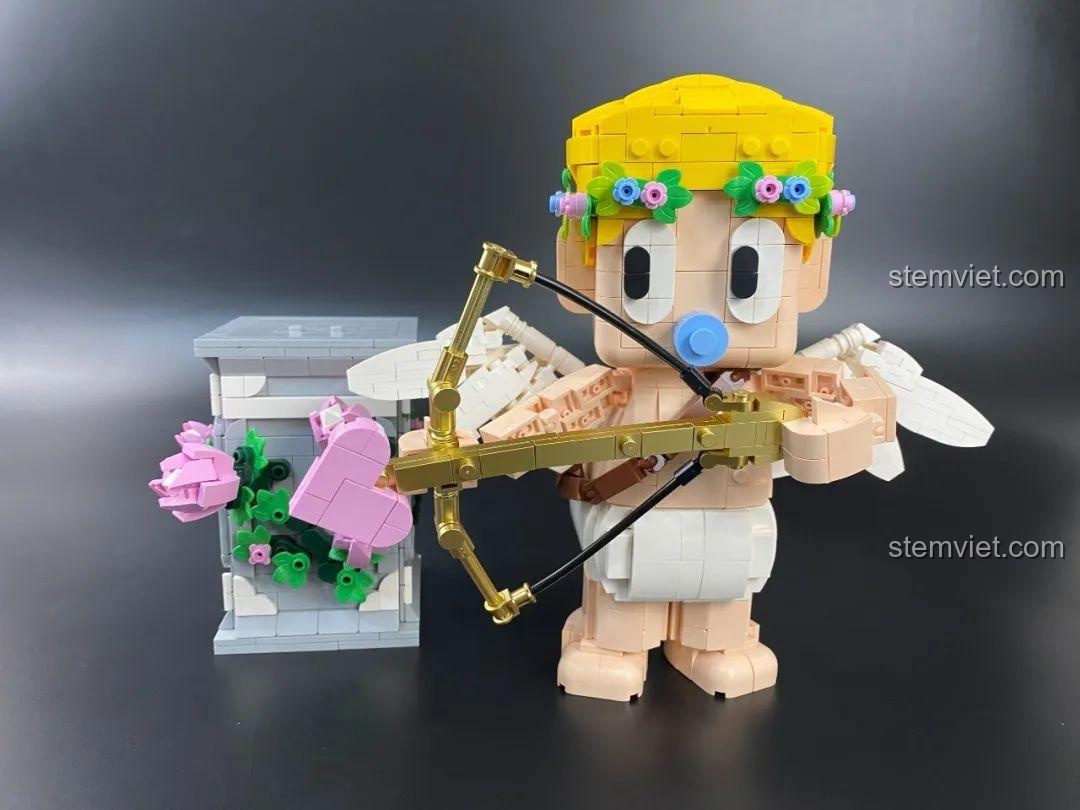 Góc nhìn phía sau của bộ khối lắp ghép Tượng Thần Tình Yêu Cupid ngồi trên bệ, cho thấy chi tiết đôi cánh và phần lưng.