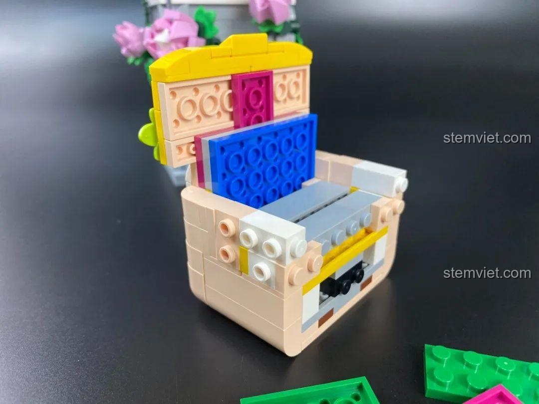 Mũi tên tình yêu màu vàng và xám của bộ lắp ráp DOKI 846681 Tượng Thần Tình Yêu Cupid được cầm trên tay.