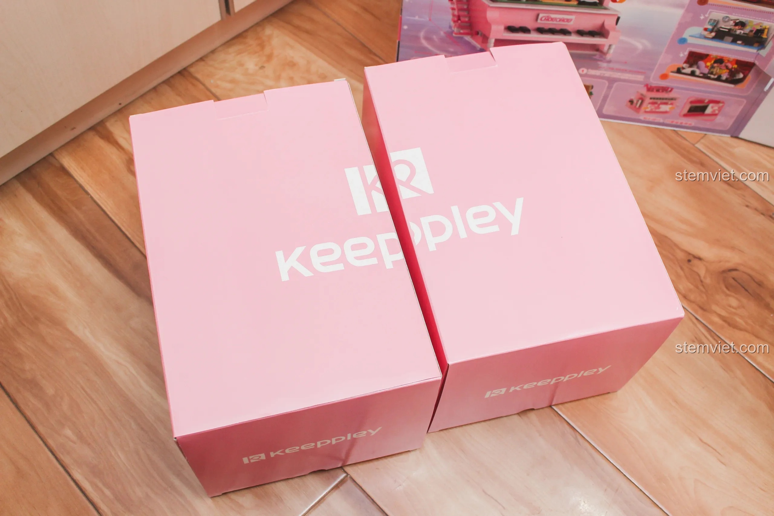 Hai hộp đựng chi tiết lắp ráp màu hồng của bộ Keeppley DZ0155 được đặt cạnh nhau, thể hiện sự chỉn chu.