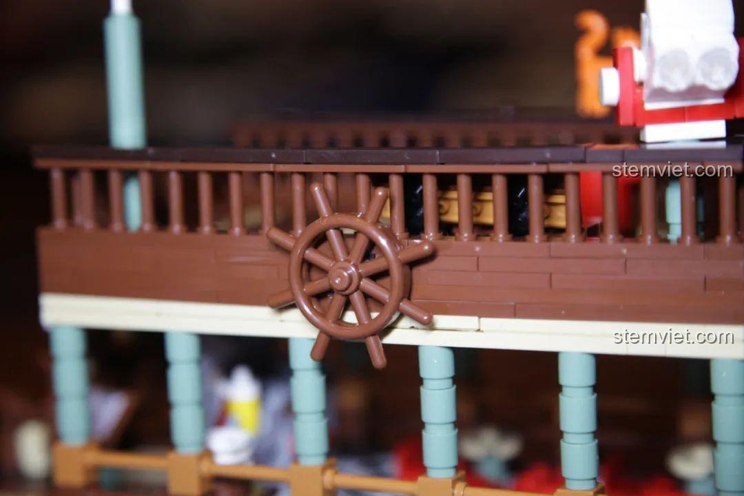 Góc câu cá thư giãn trên bến tàu với ghế, cần câu và thùng đựng cá, tạo không gian chơi đa dạng.