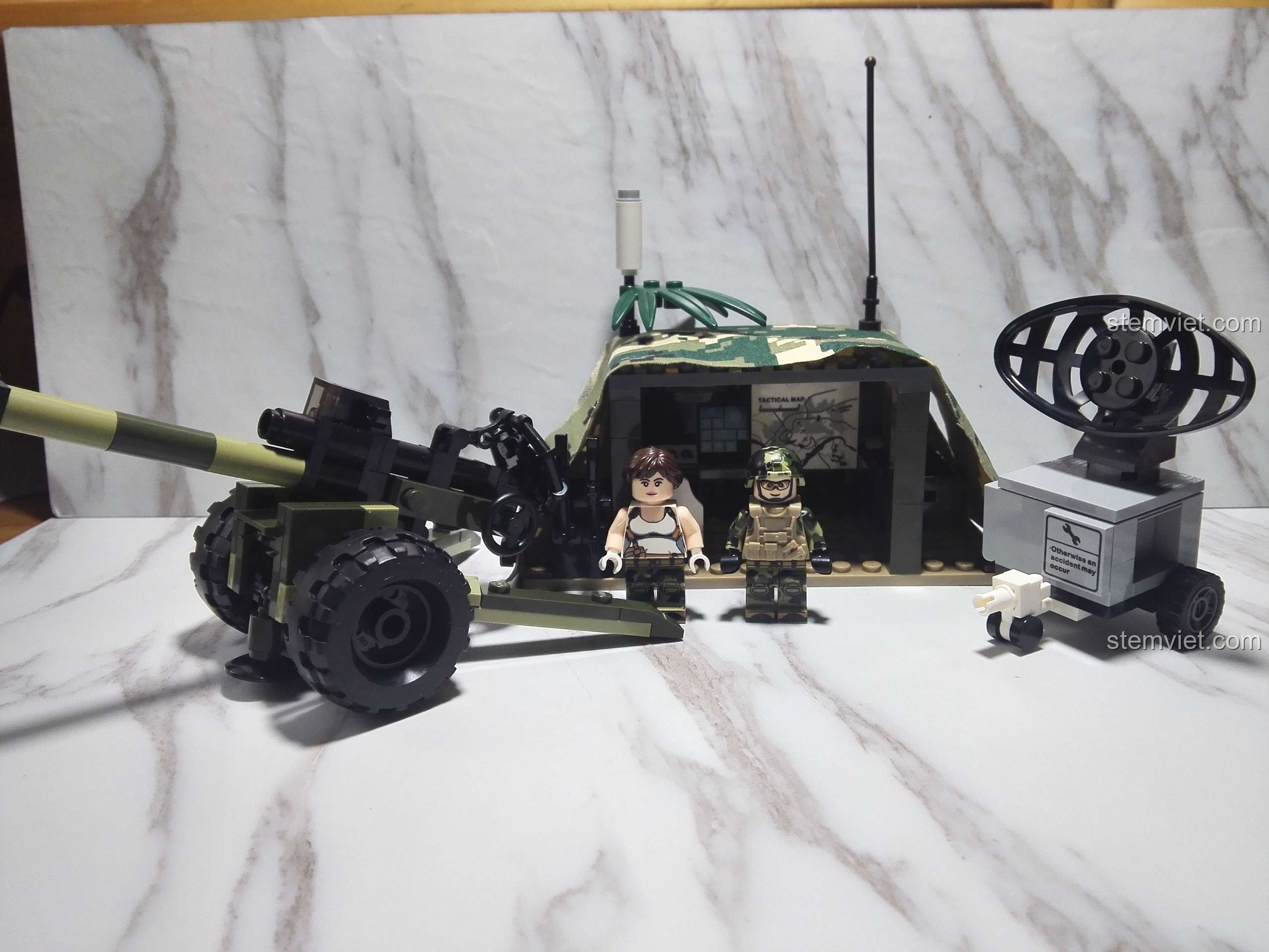 Hai minifigure chính của bộ GUDI 8032 đứng trước toàn bộ mô hình Trận địa pháo dã chiến đã hoàn thành.