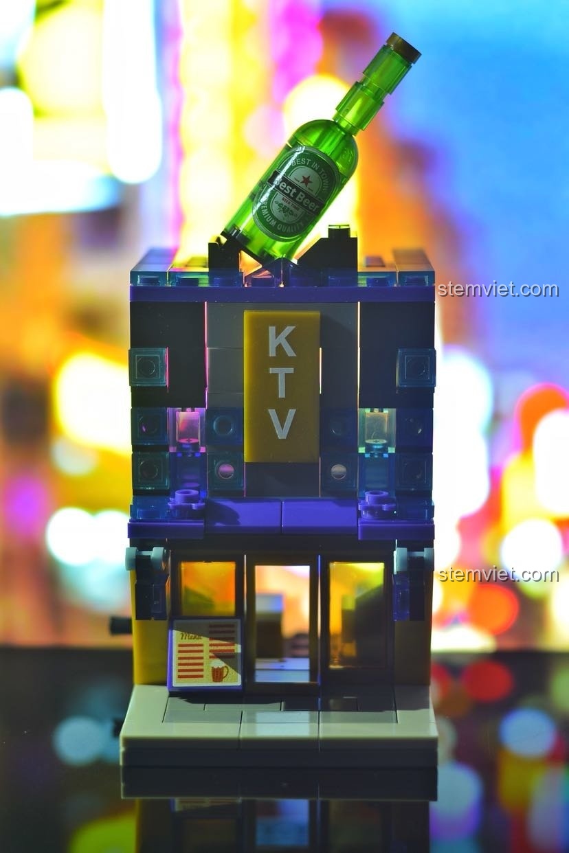 Mô hình quán KTV Sembo 6021 được chụp với nền là ánh đèn bokeh, tạo hiệu ứng cảnh đêm thành phố.