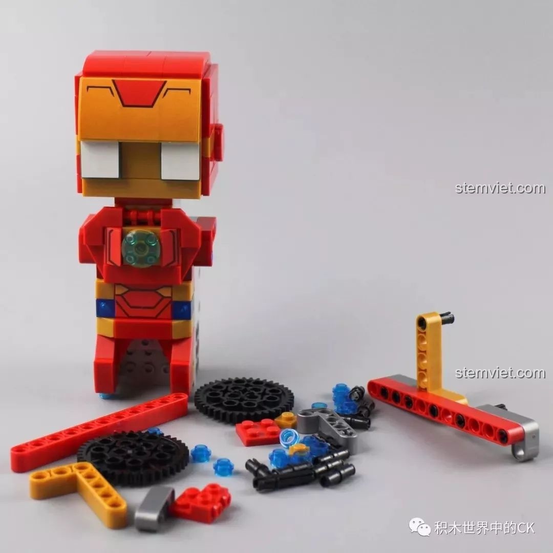 Mô hình Iron Man đã hoàn thành phần đầu và thân, bên cạnh là các chi tiết bánh xích chưa lắp.