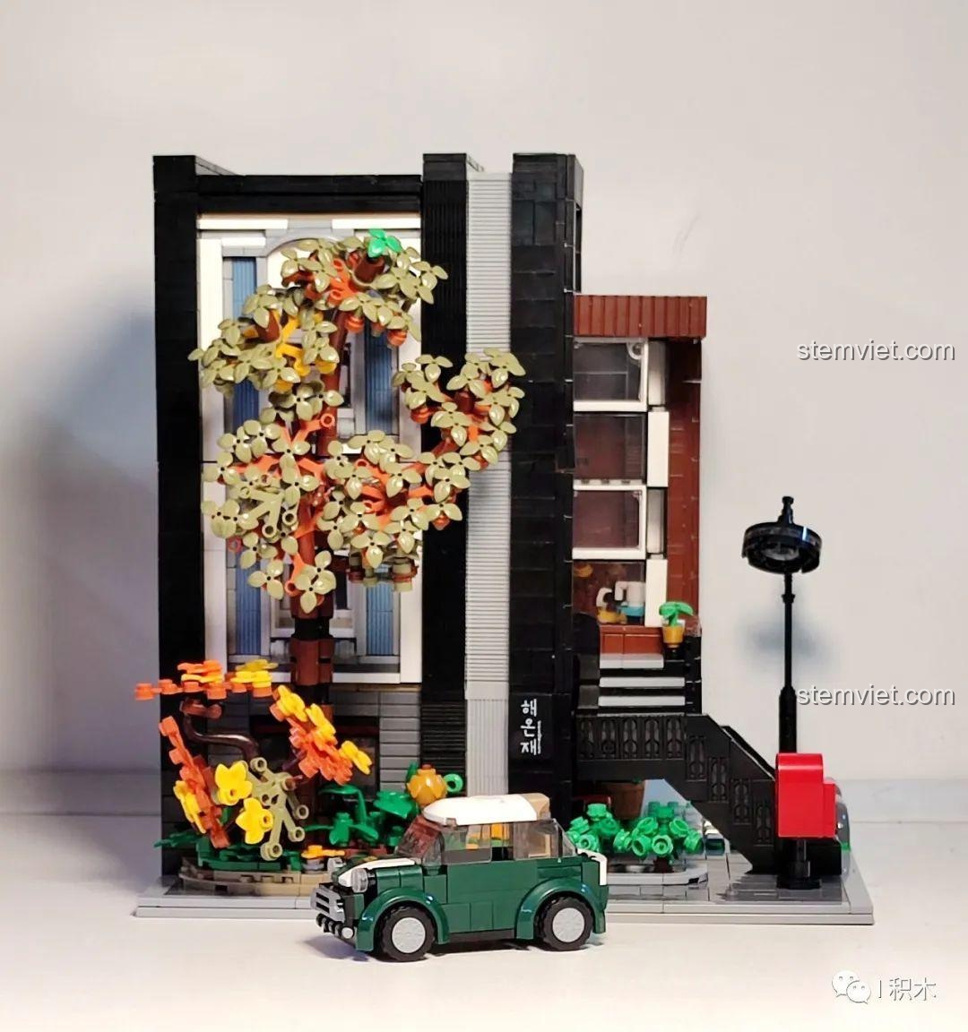 Mô hình XMORK 10205 gần hoàn thiện với cây xanh, xe hơi và các chi tiết ngoại thất khác.