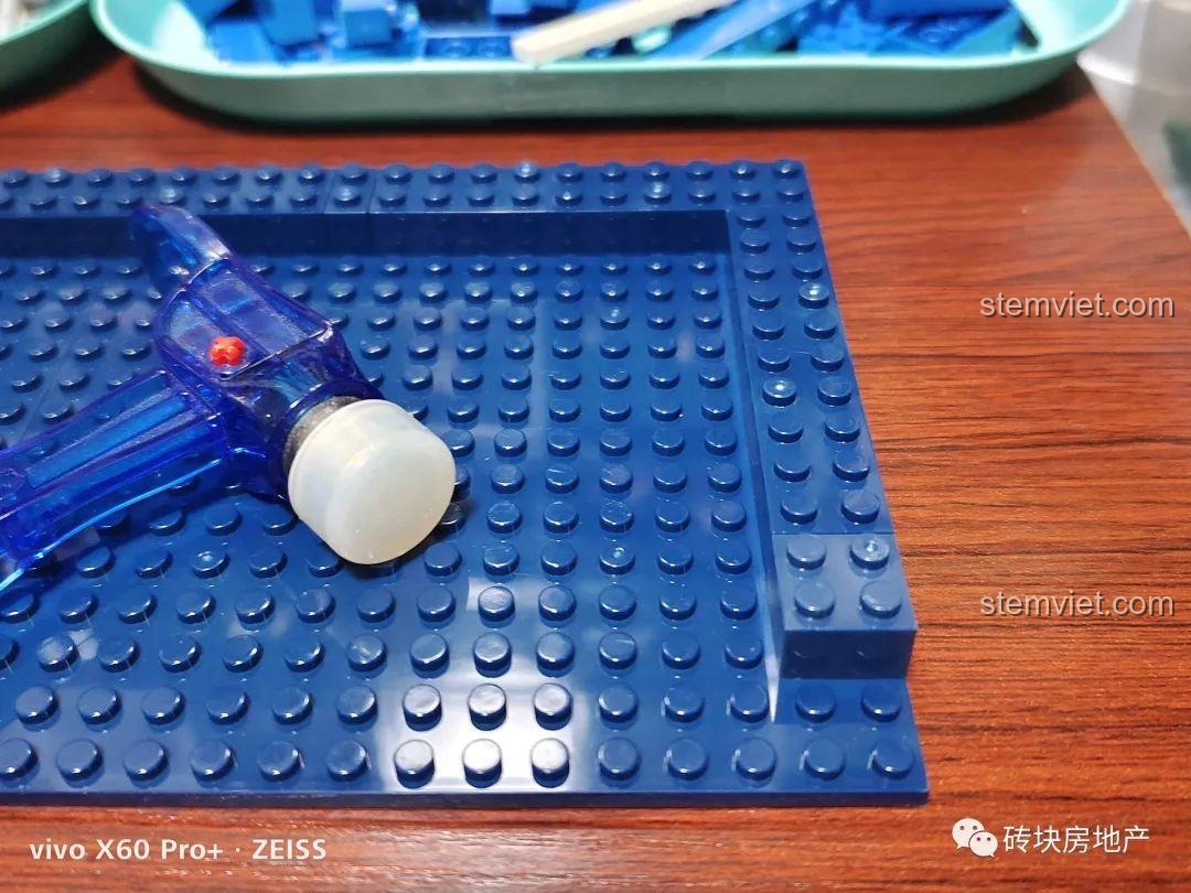 Dụng cụ gỡ gạch màu xanh trong suốt đi kèm trong bộ đồ chơi mô hình Hộp nhạc lướt sóng KAZI tiết kiệm.