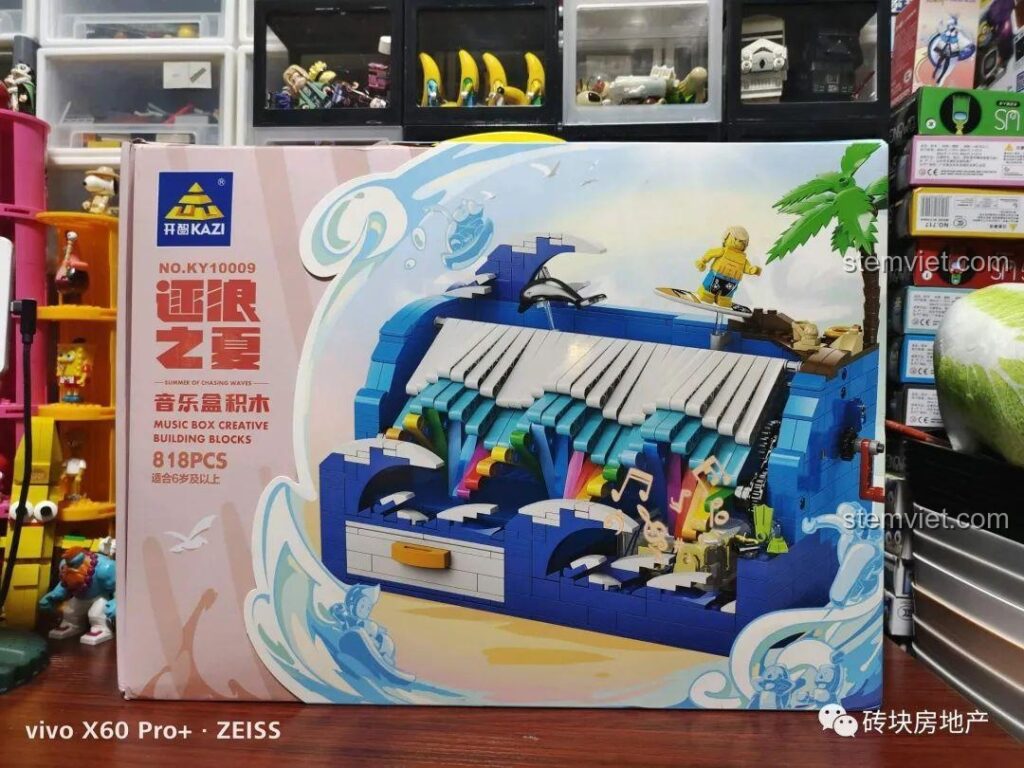 Mặt trước vỏ hộp bộ lắp ráp Hộp Nhạc Mùa Hè Đuổi Sóng KAZI KY10009 với hình ảnh sản phẩm hoàn thiện đầy màu sắc.