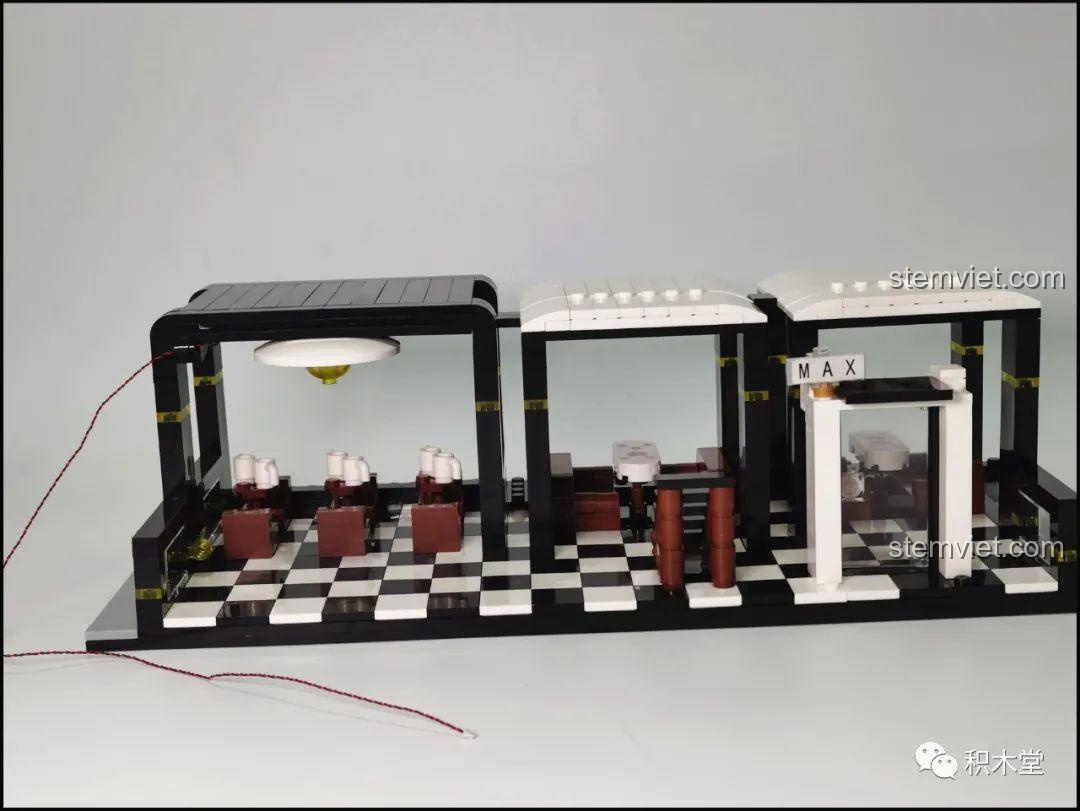 Chi tiết đường đi dây đèn LED thông minh qua các lỗ trên mảnh ghép của bộ lắp ghép Juhang Technology 86007 Quán Cà Phê Góc Phố, đảm bảo an toàn và thẩm mỹ.