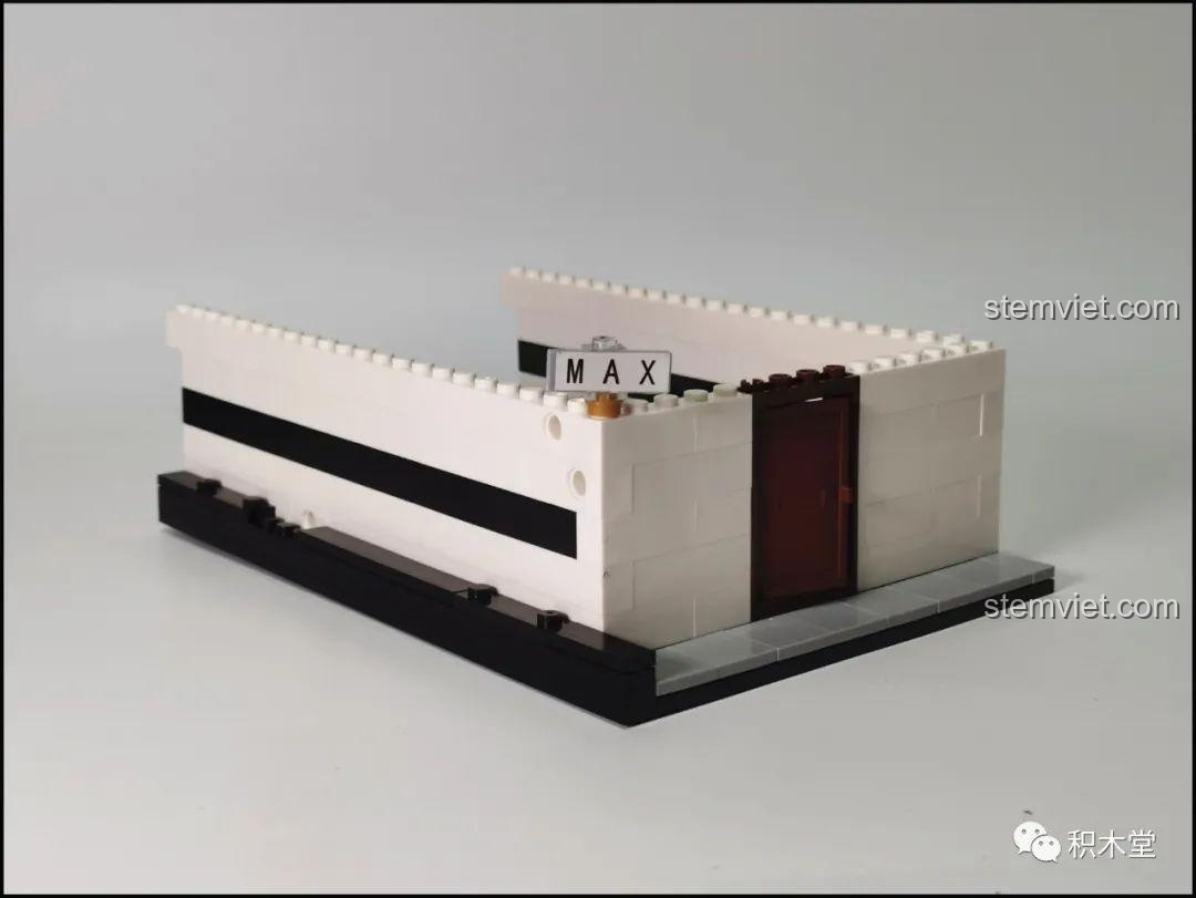 Chi tiết chữ 'M' được tạo từ các mảnh ghép trên tường của bộ lắp ghép Juhang Technology 86007 Quán Cà Phê Góc Phố, thể hiện khả năng tùy biến sáng tạo.