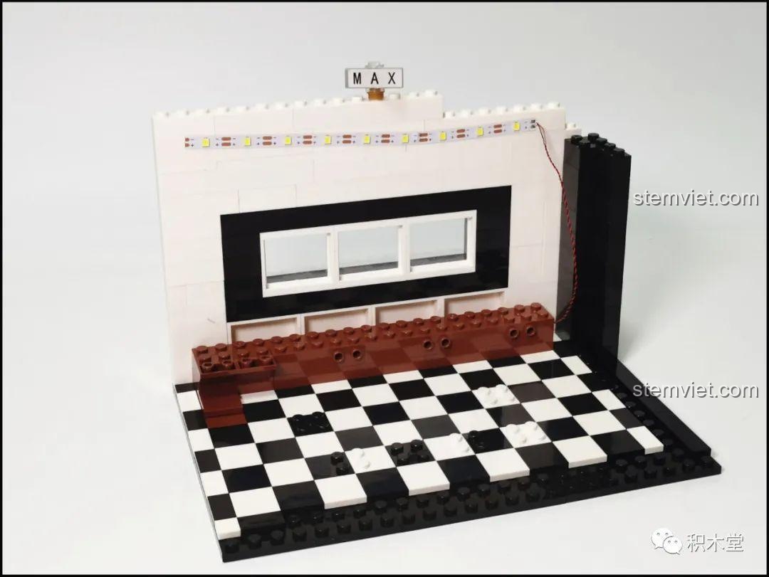 Chữ "CAFE" được ghép từ các mảnh ghép trên mái của bộ lắp ghép Juhang Technology 86007 Quán Cà Phê Góc Phố, thể hiện sự sáng tạo trong thiết kế.