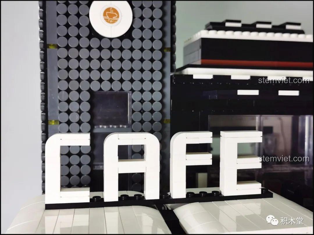 Mô hình Quán Cà Phê Góc Phố Juhang Technology 86007 từ góc nhìn phía sau, làm nổi bật cấu trúc thang máy và các chi tiết mặt sau của tòa nhà.