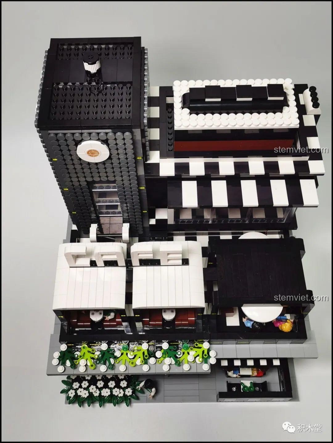 Mô hình Quán Cà Phê Góc Phố Juhang Technology 86007 từ góc nhìn nghiêng, làm nổi bật các tầng và ban công, cùng với biển hiệu cà phê lớn.