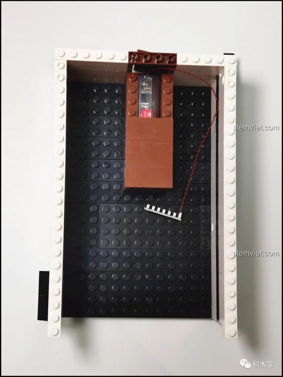 Phiên bản tùy chỉnh của chữ 'M' trên tường của bộ lắp ghép Juhang Technology 86007 Quán Cà Phê Góc Phố, cho thấy sự linh hoạt trong việc thay đổi thiết kế.