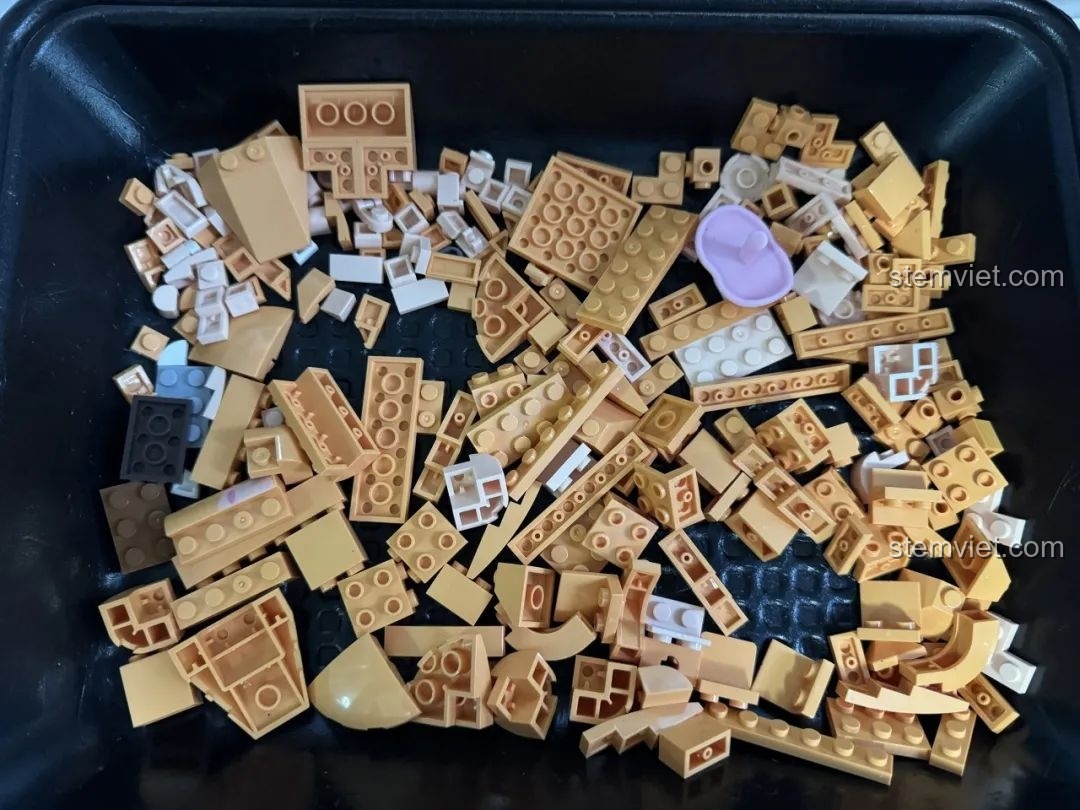 Các mảnh ghép màu cam và be của bộ Kaido KD99002-3 Thú Cưng Để Bàn: Đười Ươi Thông Minh được đổ ra khay.