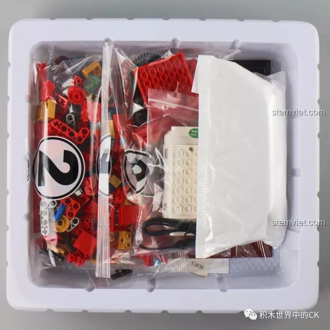 Khay nhựa bên trong hộp đồ chơi lắp ráp Mould King 13038, chứa các túi chi tiết và bộ điều khiển.