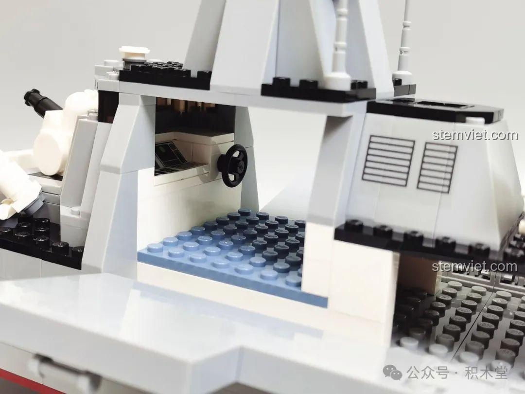 Không gian bên trong khoang lái của mô hình Tàu khu trục GUDI 8028 với bảng điều khiển và vô lăng.