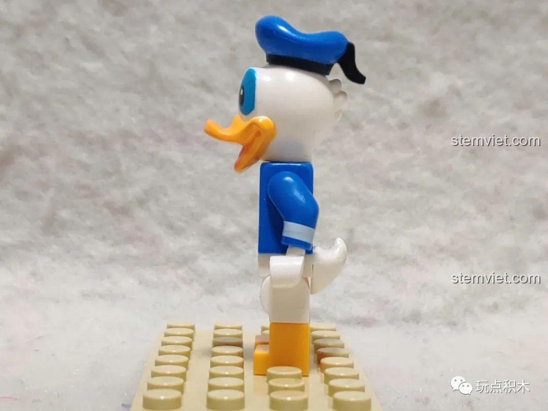 Minifigure Vịt Donald trong tư thế cử động tay, cho thấy các khớp linh hoạt.