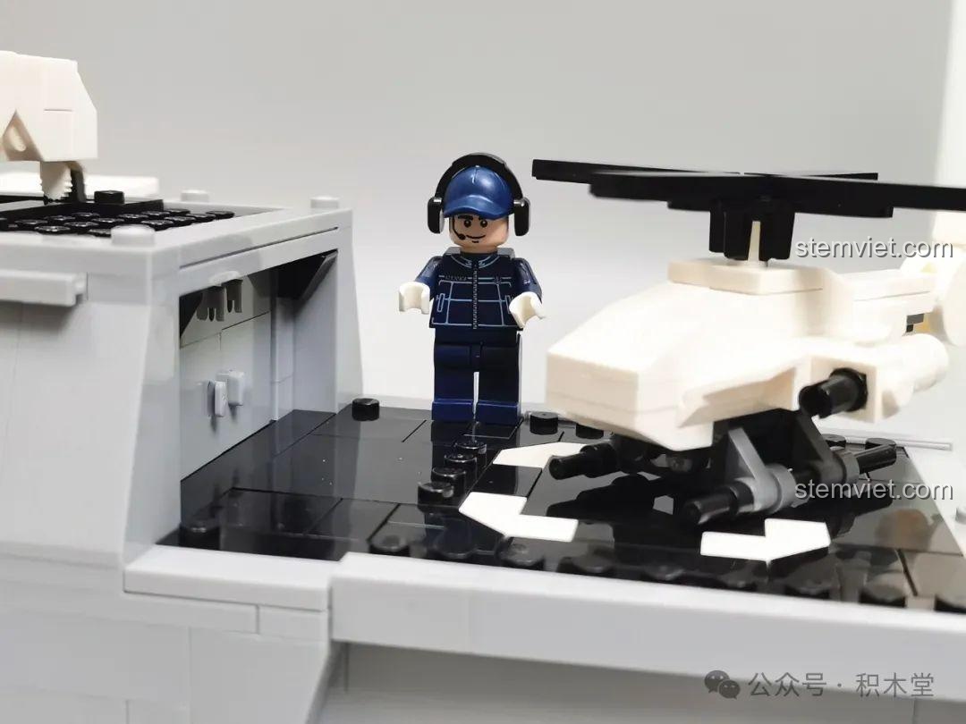 Minifigure sĩ quan đứng trên boong tàu gần trực thăng, tạo nên một kịch bản chơi thú vị với bộ GUDI 8028.